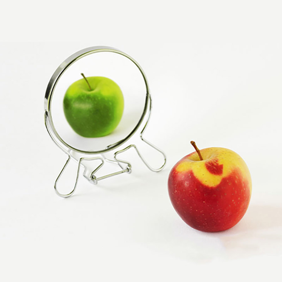 A red and green apple in front of a mirror.