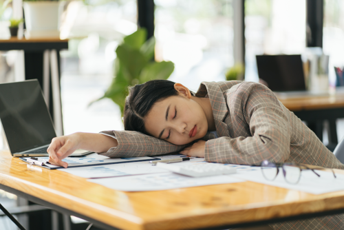 Woman asleep at desk.