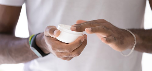 Man holding skin cream.