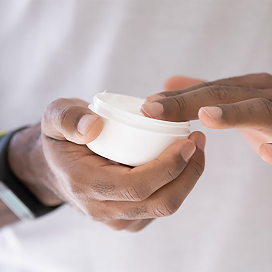 Man holding skin cream.